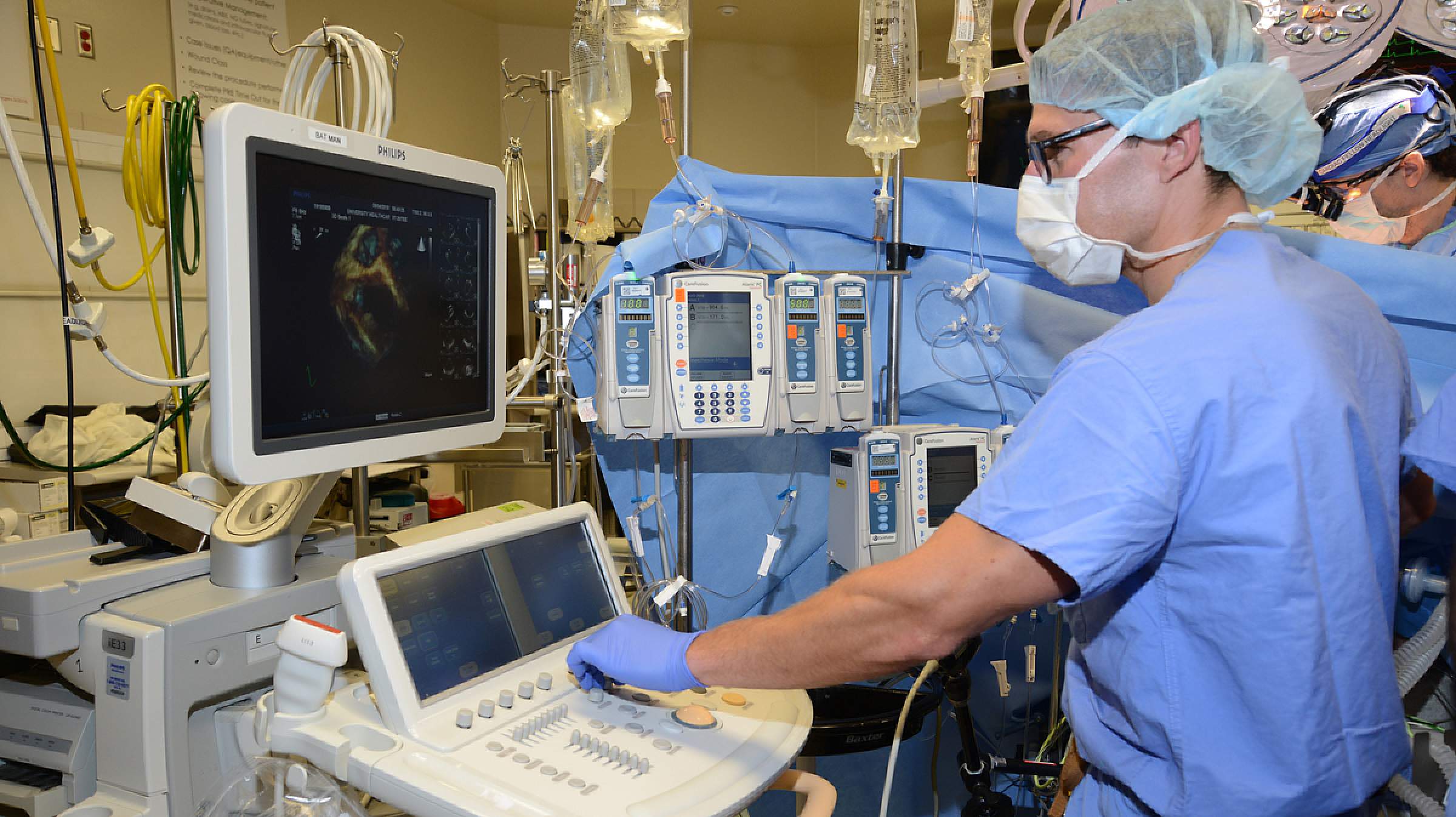 A cardiac anesthesiologist in an OR reading an ultrasound.